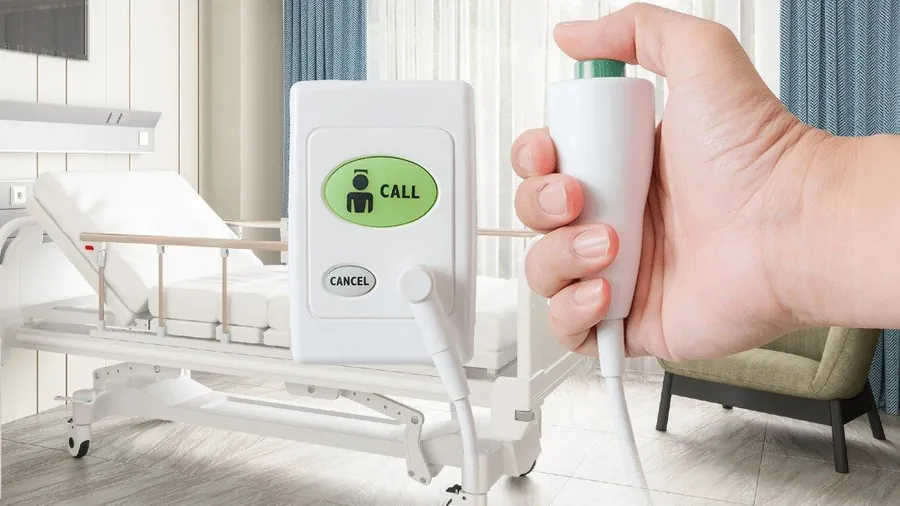 The Austco nurse-call system in a hospital ward setting — wall-mounted call point and bed-side handset.